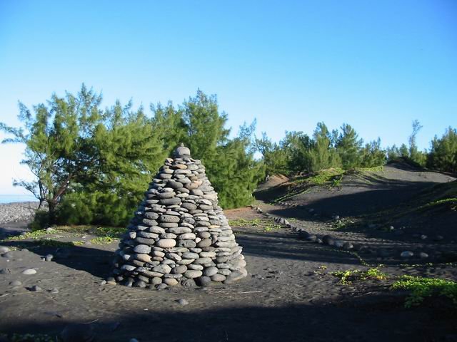 Entre la mer et le sentier sont érigés de nombreux tumulus de galets.