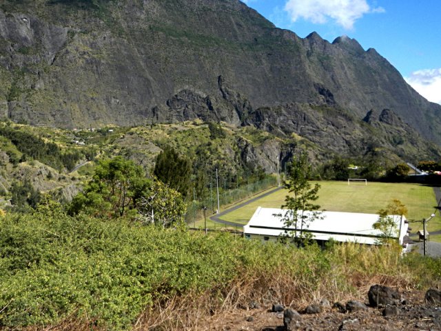 Un sentier caillouteux remonte à partir du stade