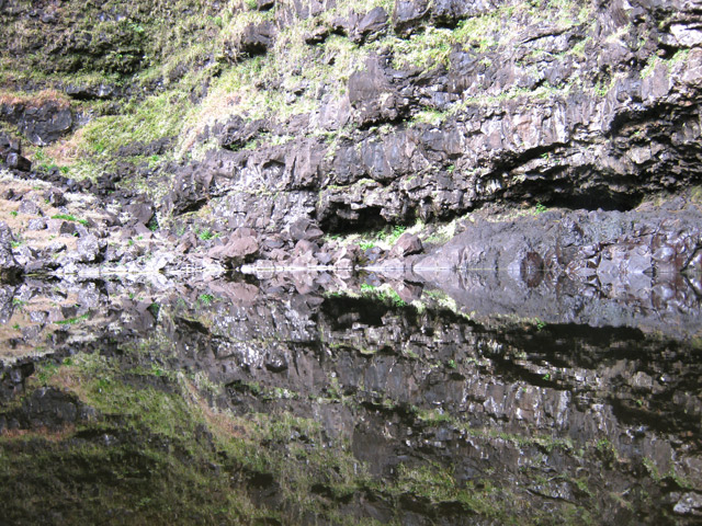 Le miroir du bassin reflète deux des trois grottes situées tout près