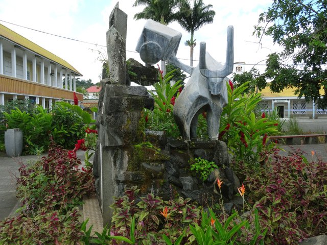 Tout près du monument, une fontaine sculptée et fleurie