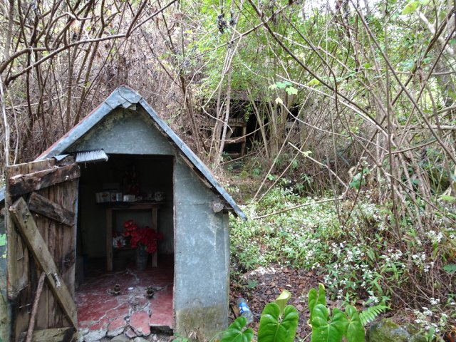 Une vieille case abandonnée près d'un oratoire en meilleur état