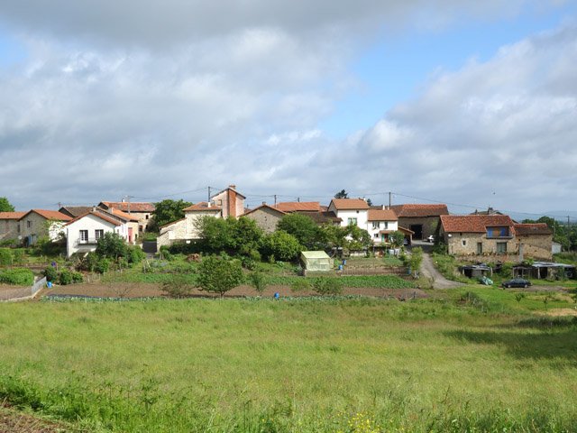 Hameau paisible au milieu des prairies et cultures
