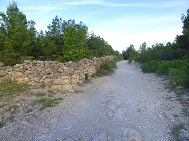 Large sentier bordant des enclos en pierre